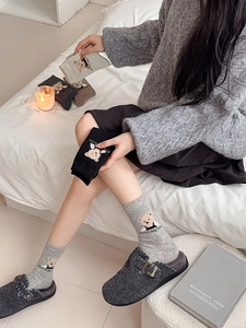 Détail de chaussettes d'hiver en laine assorties avec broderie d'ourson mignon
