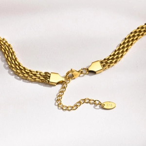 Gros plan sur le collier à mailles dorées avec fermoir mousqueton et gravure K18