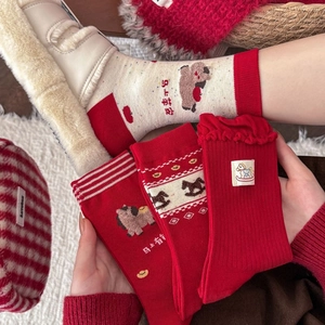 Close-up of festive red and cream cotton socks featuring horse patterns and frilled cuffs