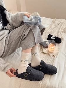 Gros plan de chaussettes en laine à motifs avec des mules en feutre gris douillettes
