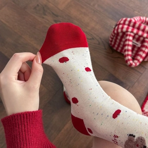 Elastic detail of red and white cotton socks featuring a cute bear and apple print