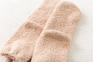 Close-up of thick light brown plush coral fleece socks with soft fuzzy texture details