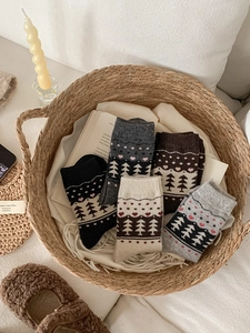 Detail of five pairs of wool socks with Nordic Fair Isle patterns in a woven basket