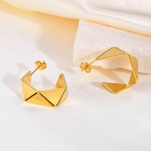 Irregular C-shaped gold geometric earrings with a faceted diamond texture design