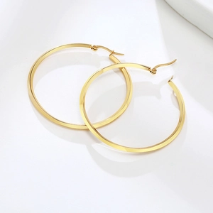 Detailed view of large gold-plated hoop earring with flat surface on white background