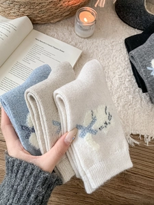 Gros plan de chaussettes en laine épaisses avec motif jacquard chat aux tons doux
