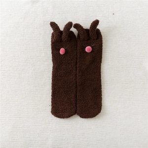 Detail of plush coral fleece rabbit socks in brown with 3D ears and soft pom-pom nose
