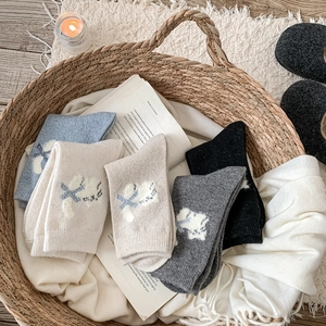 Détail de la broderie chat sur des chaussettes en laine chaudes dans un décor cosy