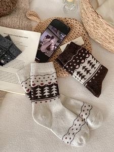 Close-up of Fair Isle wool socks featuring pine tree and red heart knit patterns