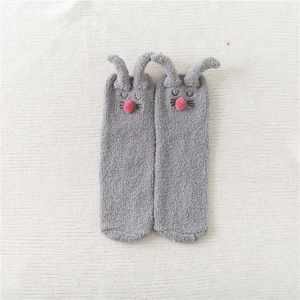 Detailed view of grey fuzzy coral fleece socks with 3D bunny ears and pink pom-pom nose