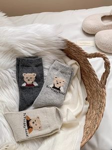 Trois paires de chaussettes en laine à motif ours en peluche dans un panier tressé