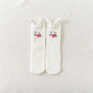 Close-up of white plush bunny slipper socks with soft coral fleece and cute 3D rabbit ears