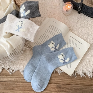 Gros plan de chaussettes en laine avec motif chat blanc et bord-côte confortable