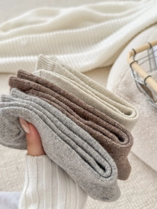 Primo piano di calze invernali spesse in lana grigio e beige con polsini a coste