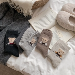 Détail de chaussettes en laine avec broderie ours en peluche et maille douce d'hiver
