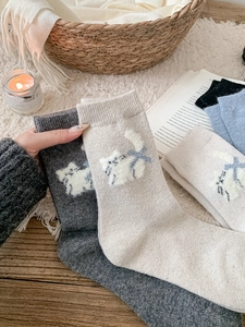 Gros plan détaillé de chaussettes en laine avec motif chat 3D et petit nœud bleu