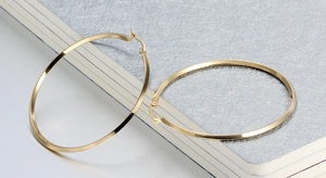 Detailed view of large gold-plated hoop earrings with a high-polished mirror finish