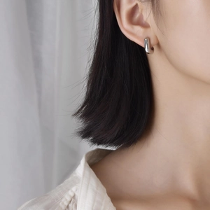 Créoles géométriques minimalistes en argent poli portées par un mannequin féminin