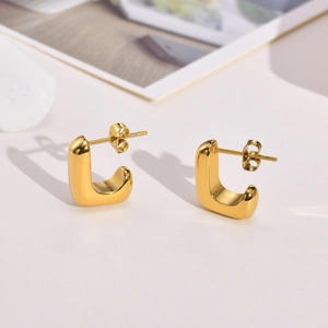 Détail de boucles d'oreilles dorées en forme de U avec fini poli et fermoirs papillon