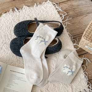 Texture détaillée des chaussettes en laine avec jacquard de chat et motif en croix