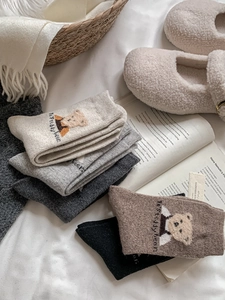 Gros plan de chaussettes d'hiver en laine avec broderie ours en cinq couleurs neutres