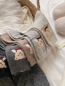 Détail de chaussettes en laine avec broderie ours en 3D et texture en maille chaude