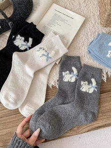 Détail de chaussettes en laine avec jacquard de chat mignon et nœud bleu décoratif