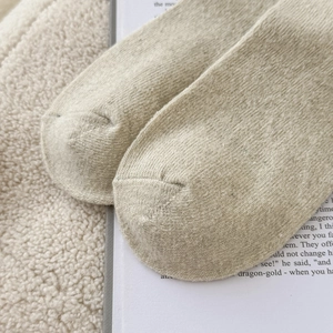 Macro di calze di lana beige che mostrano la cucitura senza cuciture e la trama calda