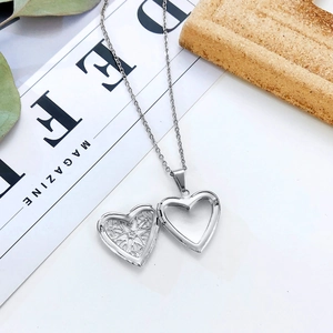 Detail of open heart locket necklace showing inner pattern and photo slot