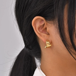 Boucles d'oreilles créoles dorées en C au design plissé géométrique sur un mannequin
