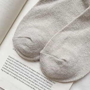 Gros plan de chaussettes en laine avoine avec texture tricotée fine et pointe renforcée