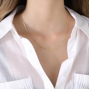 Close-up of elegant 18k gold-plated S-chain necklace worn on a female model