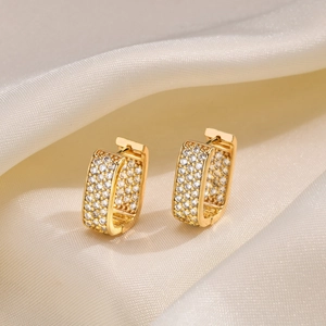 Elegant gold rectangle hoop earrings with pavé zircons on soft white silk fabric