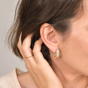Close-up of elegant gold starburst hoop earrings with sparkling cubic zirconia on model