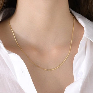 Elegant 18k gold plated stainless steel S-chain necklace worn by a model on a white shirt