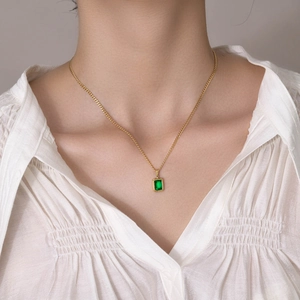 Close-up of gold stainless steel necklace with rectangular emerald green zircon pendant