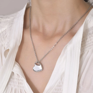 Close-up of heart-shaped memorial pendant engraved with Forever In My Heart on a model