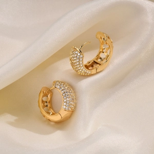 Detailed view of gold C-shaped hoop earrings with micro-pave zircons and geometric cutouts