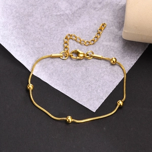 Gros plan du bracelet chaîne serpent doré avec quatre perles et fermoir mousqueton réglable