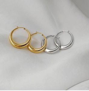 Boucles d'oreilles créoles épaisses polies or et argent sur tissu en soie blanche