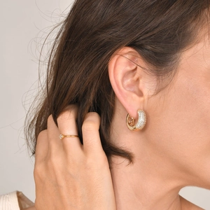 Golden C-shaped hoop earrings with zircons and matching diamond ring on model
