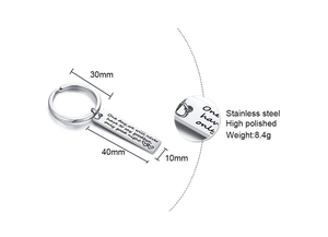 Macro detail of polished stainless steel keychain with engraved text and product dimensions