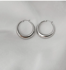 Gros plan de boucles d'oreilles créoles argentées avec finition polie brillante