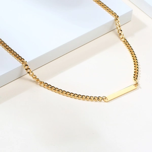 Detailed view of 18K gold plated stainless steel curb chain with a polished bar pendant