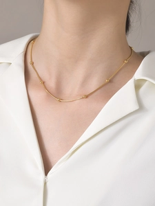 Collier minimaliste en acier inoxydable doré à mailles serpent porté par un modèle