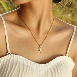 Détail d'un collier pendentif tulipe doré orné d'un zircon clair sur un modèle