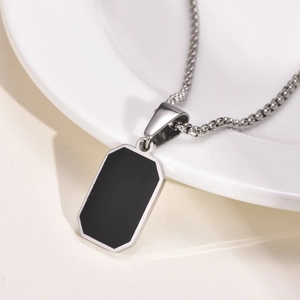 Detailansicht einer silbernen Edelstahl-Halskette mit schwarzem Harzanhänger im Dog-Tag-Stil