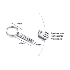 Macro view of stainless steel keychain with quote engraving and dimension markings