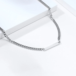Macro detail of silver stainless steel curb chain with blank rectangular bar pendant