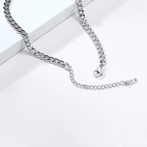 Macro shot of silver stainless steel curb chain with lobster clasp and K18 tag detail